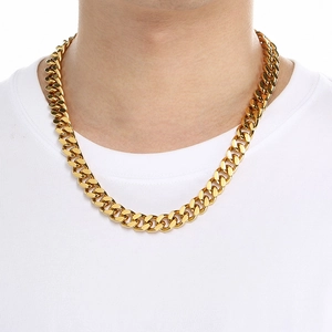 Golden Cuban link necklace worn by a male model over a white T-shirt detail view