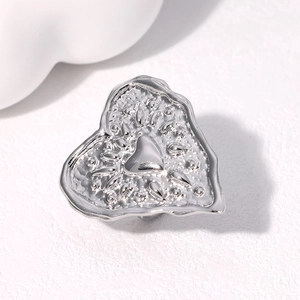 Macro shot of silver heart ring featuring textured hammered finish and polished center detail