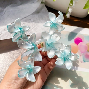 Blue gradient plumeria flower hair claw clip with a pearlescent finish and metal spring