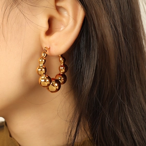 Elegant gold metal hoop earrings with polished spheres in a modern geometric design