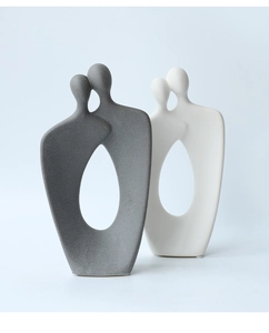 Dettaglio di sculture di coppia in ceramica che mostra texture grigio opaco e bianco sporco