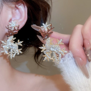 Close-up of sparkling Christmas reindeer stud earrings featuring pavé rhinestones and gold details