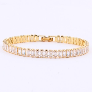 Close-up of gold-plated tennis bracelet featuring rectangular white cubic zirconia stones