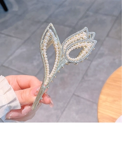Detail of tulip hair claw clip with pearls and rhinestones in golden finish