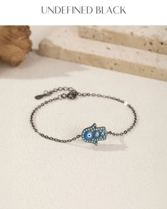 Macro shot of S925 silver Hamsa Hand charm bracelet with blue evil eye details