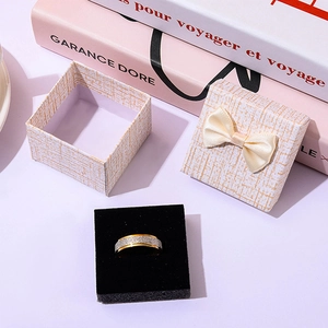 Two-tone matte ring displayed with a cream ribbon gift box on a stylish background