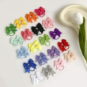 Vista piatta di 20 colori di fiocchi per capelli in grosgrain disposti a coppie su bianco