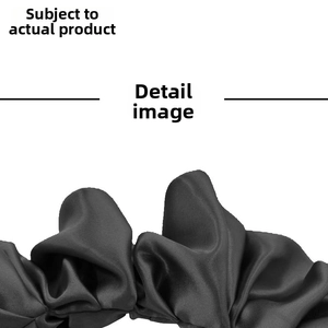 Close-up detail of black satin pleated elastic headband with smooth silk-like texture