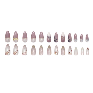 Purple gradient press-on nails with 3D gold bows, pearls, and floral glitter designs