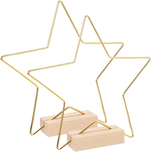 Detail of two golden metal stars with natural rectangular wooden bases for wedding decor