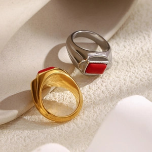 Macro shot of 18K gold and silver stainless steel rings with rectangular red stone inlays