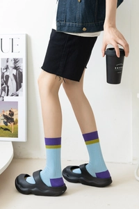 Close-up of color-block ribbed cotton mid-calf socks in light blue and mustard yellow