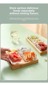 Close-up of clear square glass fruit bowls with gold rims on a bamboo wooden tray