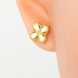 Elegant gold clover stud earrings with white inlay and beaded edge on model ear