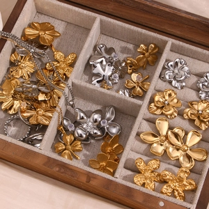 Detailed collection of floral gold and silver jewelry displayed in a premium linen jewelry box