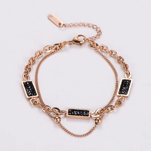 Detail of rose gold double-layered stainless steel bracelet with black stone charms