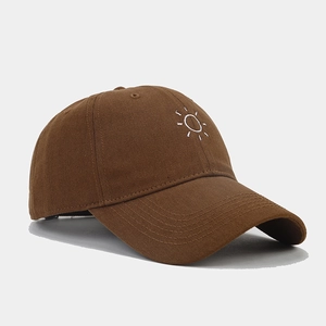 Close-up of sun embroidery on brown twill cotton baseball cap with fine stitching details