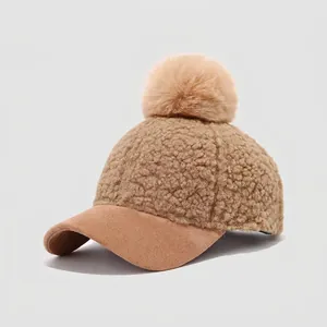 Detailed view of kids lamb wool baseball cap with suede brim and plush pompom detail