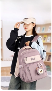 Detail of light purple waterproof backpack with multi-layer pockets and bear charm