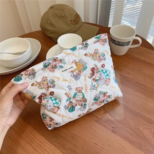 Detailed view of bear floral quilted cotton makeup bag with simple wish label on wood table