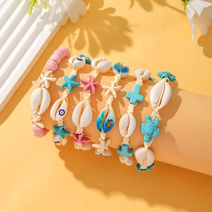 Detail of beach bracelets with shells and sea stars on a warm yellow display stand