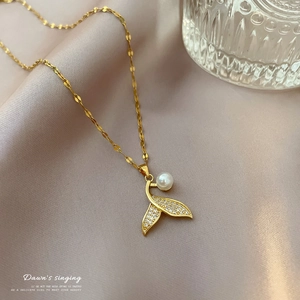 Elegant mermaid tail necklace with white pearl and sparkling crystals on silk background