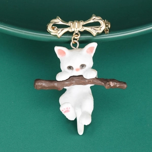 Detail of cute cat on branch brooch with gold bow and pink ear accents