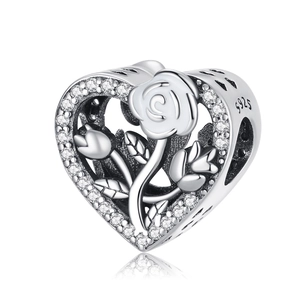 Macro view of heart charm with white enamel rose and micro-pave crystal edges