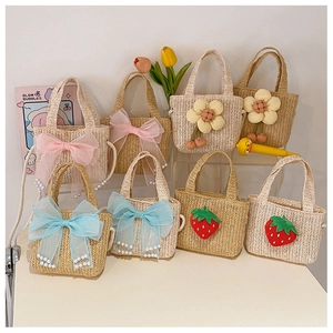 Detailed view of handmade straw bags with floral, strawberry, and bow designs for kids