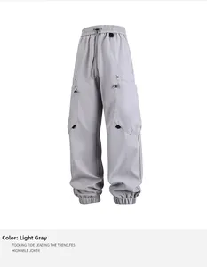 Detalle de pantalones cargo gris claro con bolsillos múltiples y cintura con cordón