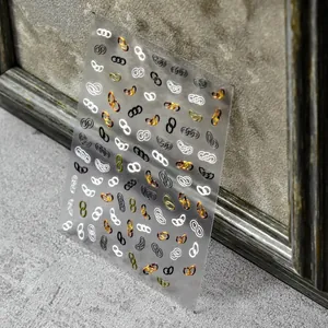 3D Relief Nageltattoos t01741 mit bunten Kettenmotiven auf grauem Hintergrund