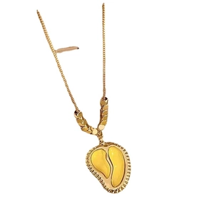 Minimalist gold heart pendant necklace with yellow enamel inlay on a clean white background