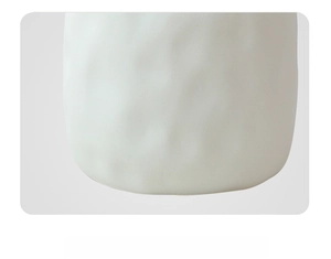 Detail of white ceramic vase bottom with non-slip pads and smooth polished finish