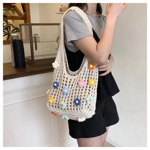 Detail of hand-crocheted beige tote bag with colorful 3D floral accents and knit texture