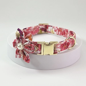 Detail of pink floral dog collar with gold metal buckle and pearl fabric flower accessory