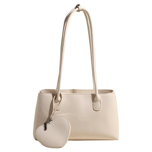 Minimalist cream white tote bag with heart pendant accessory and premium leather texture
