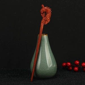 Detailed view of hand-carved sandalwood hair pin featuring a mythical phoenix design