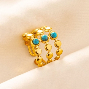 Detailed macro view of triple-row gold beaded ring with three turquoise stones