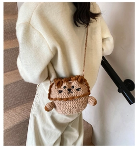 Detail view of a handmade crochet lion shoulder bag with a 3D mane and woven strap