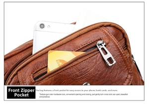 Détail de la poche frontale zippée en cuir marron contenant un téléphone et des cartes