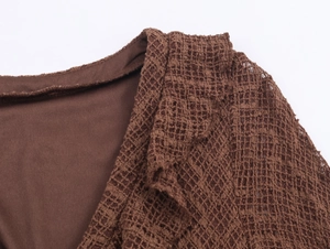 Detailed close-up of brown knit dress featuring a deep V-neck and open mesh texture