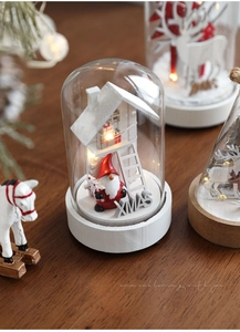 Close-up of lighted Christmas glass dome with Santa gnome and XMAS wooden base