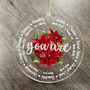Detail of round acrylic Christmas ornament with red poinsettia and biblical verses