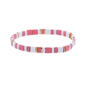 Detail of bohemian stretch bracelet with pink white and gold flat beads