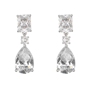 Macro detail of emerald-cut and pear-shaped Paraiba tourmaline drop earrings in silver