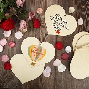 Flat lay of heart-shaped wooden tags with Happy Valentine's Day text and floral accents
