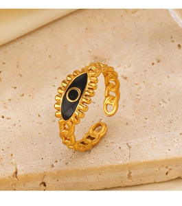 Détail de la bague œil protecteur dorée avec texture chaîne sur pierre beige