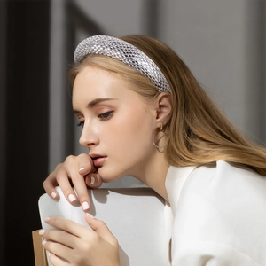 Baroque style silver rhinestone headband with matching gold hoop earrings on a model