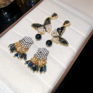 Detailed macro view of crystal butterfly earrings and elegant long gold tassel drop charms