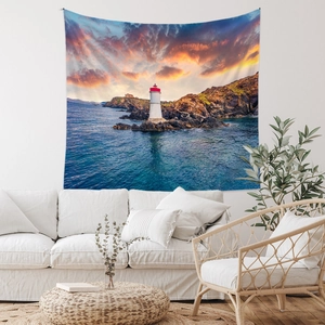 Détail d'une tapisserie bohème avec phare au coucher du soleil suspendue sur un canapé